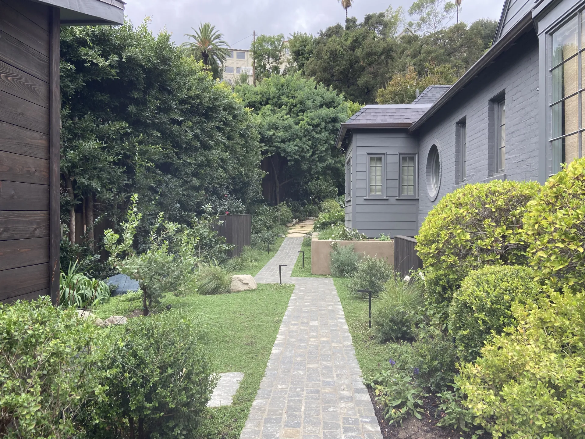 Brick walkway between lush garden beds